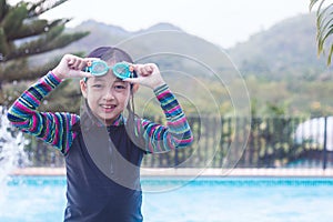 Happy asian child girl in a  swimming pool