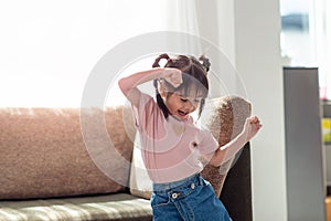 Happy Asian child having fun and dancing in a room