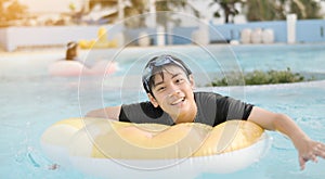 Happy asian child playing in swimming pool with smile face