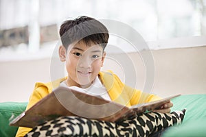 Happy asian child reading book with smile face.