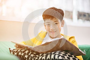 Happy asian child reading book with smile face.