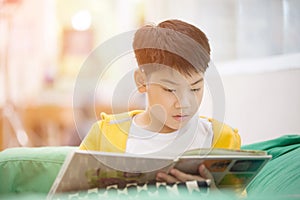 Happy asian child reading book with smile face.