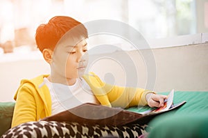 Happy asian child reading book with smile face.