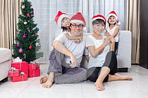 Happy Asian Chinese family sitting on the floor celebrating Christmas