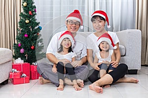 Happy Asian Chinese family sitting on the floor celebrating Christmas