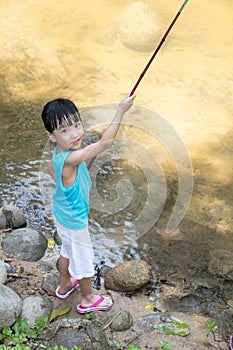 Happy Asian Chinese little girl angling with fishing rod