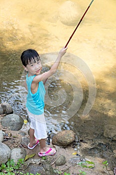 Happy Asian Chinese little girl angling with fishing rod photo