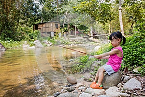 Happy Asian Chinese little girl angling with fishing rod photo