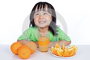 Feliz asiático chino pequeno bebiendo naranja jugo 