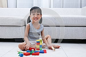 Happy Asian Chinese little girl playing blocks on the floor