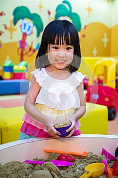 Happy Asian Chinese Little Girl Playing Kinetic Sand Indoor