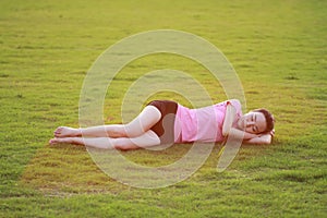 Happy Asian Chinese woman have a rest on grass