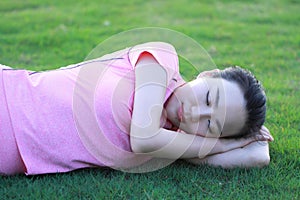 Happy Asian Chinese woman relax on grass