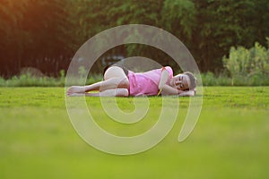 Happy Asian Chinese woman relax on grass