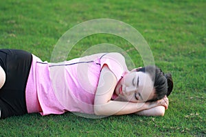 Happy Asian Chinese woman sleep on grass