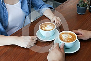 Happy Asian couple in blue jean have hot latte coffee