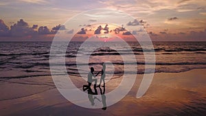 Happy Asian couple dating at the beach during travel honeymoon trip on holidays vacation outdoors. Ocean or nature sea at sunset,