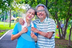 They are happy Asian couple.They give a big hug together after Jogging in park.