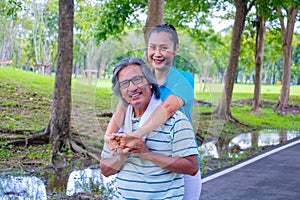 They are happy Asian couple.They give a big hug together after Jogging in park.