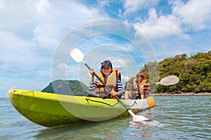 Happy asian couple kayaking together on the beatiful sea or canoe at tropical bay