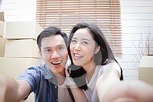 Happy asian couple moving into new home Take a smartphone and take a selfie.