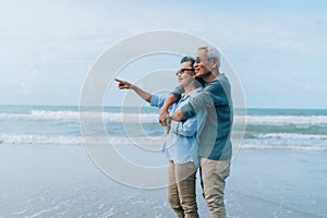 Happy asian couple senior elderly retirement resting at beach honeymoon