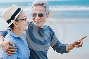 Happy asian couple senior eldery retirement resting at beach honeymoon photo