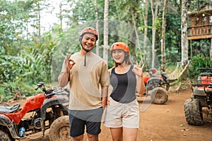 happy asian couple standing with oke hand gesture