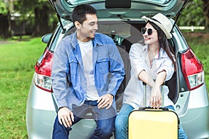 Happy Asian couple traveling and sitting in a car