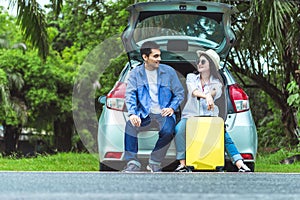 Happy Asian couple traveling and sitting in a car