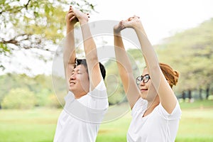Happy Asian couple in white shirt workout at the park.