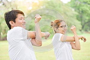 Happy Asian couple in white shirt workout at the park.