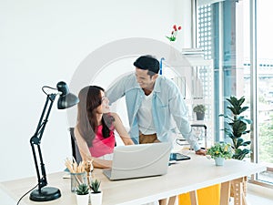 Happy Asian couple, young woman and man using tablet and laptop computer.