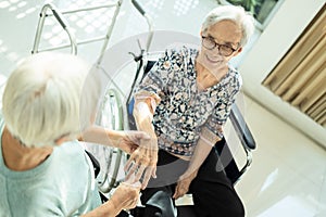 Happy asian elderly woman massaging palm and fingers of close friend senior having beriberi,hand numbness,peripheral neuropathies,