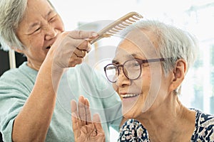 Happy asian elderly women,female senior combing hair to friend senior woman in nursing home,smiling old people or sister care,