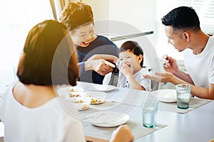 Happy Asian extended family having dinner at home full of laughter and happiness.