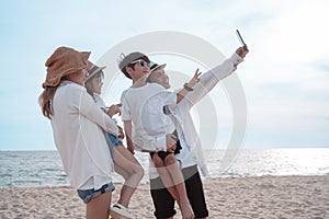 Happy asian family on the beach in holiday. of the family take a selfie.They are having fun playing enjoying on the beach. Summer