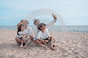 Happy asian family on the beach in holiday. of the family take a selfie.They are having fun playing enjoying on the beach. Summer