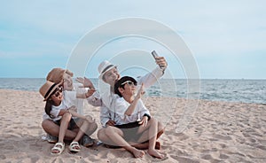 Happy asian family on the beach in holiday. of the family take a selfie.They are having fun playing enjoying on the beach. Summer