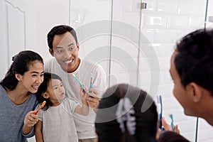 Happy asian family brush their teeth together