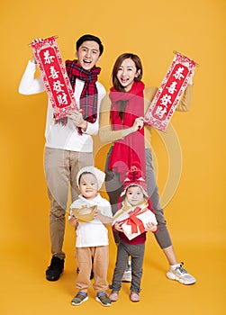 Happy asian family celebrating  chinese new year. chinese text : congratulation and  get rich