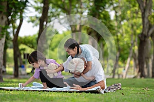 Happy Asian family children having fun and playing with her grandfather in the park