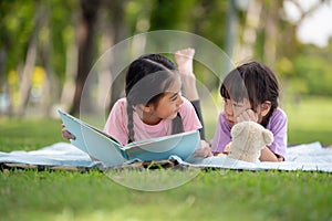 Happy Asian family children reading a book together
