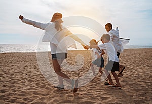 Happy asian family enjoy the sea beach at consisting father, mother,son and daughter having fun playing beach in summer vacation