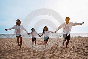 Happy asian family enjoy the sea beach at consisting father, mother,son and daughter having fun playing beach in summer vacation