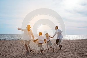 Happy asian family enjoy the sea beach at consisting father, mother,son and daughter having fun playing beach in summer vacation