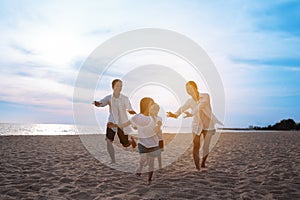 Happy asian family enjoy the sea beach at consisting father, mother,son and daughter having fun playing beach in summer vacation