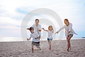 Happy asian family enjoy the sea beach at consisting father, mother,son and daughter having fun playing beach in summer vacation