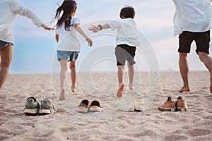 Happy asian family enjoy the sea beach at consisting father, mother,son and daughter having fun playing beach in summer vacation