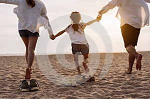Happy asian family enjoy the sea beach at consisting father, mother,son and daughter having fun playing beach in summer vacation